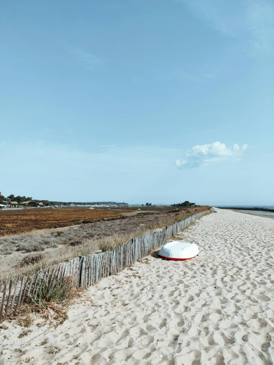 there are two large white kites on the sand near an ocean