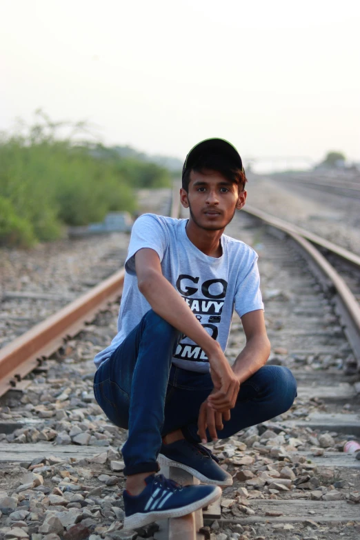 a young man on his skateboard sits on the ground