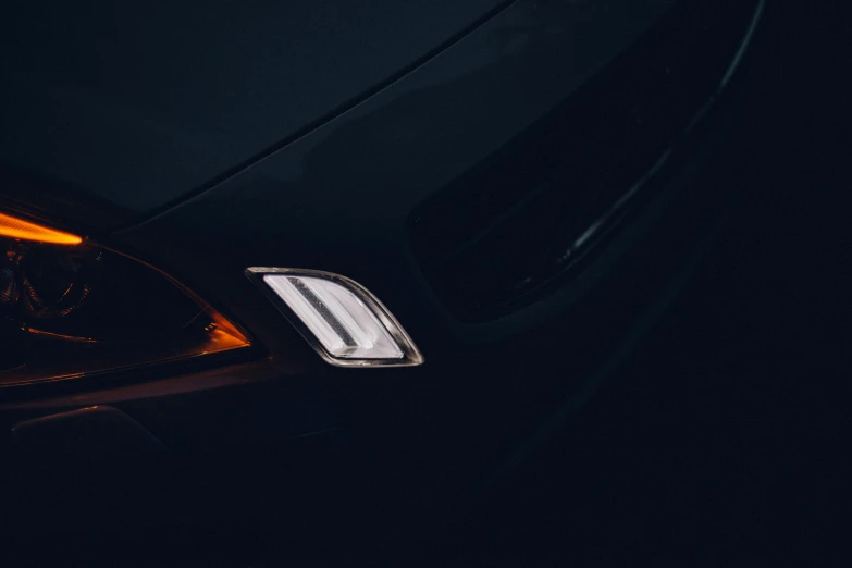 the tail lights on a car with a dark background