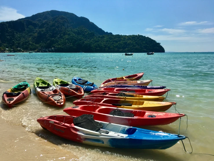 several rowboats docked along the shore of a beach