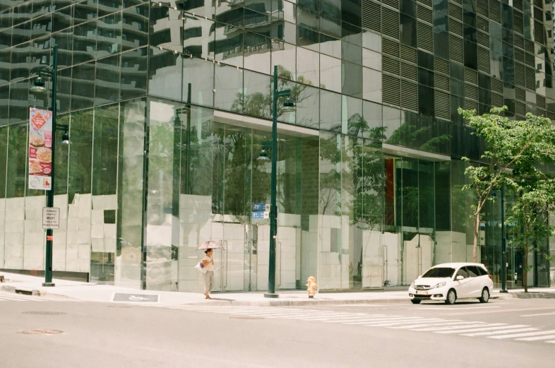 a car is parked near the glass walls of an office building