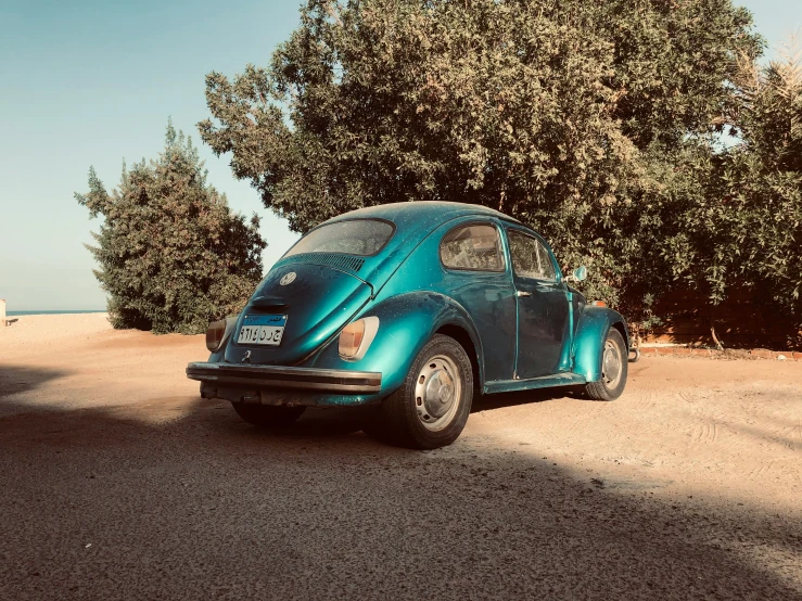 a car parked on the side of the road with trees in the background