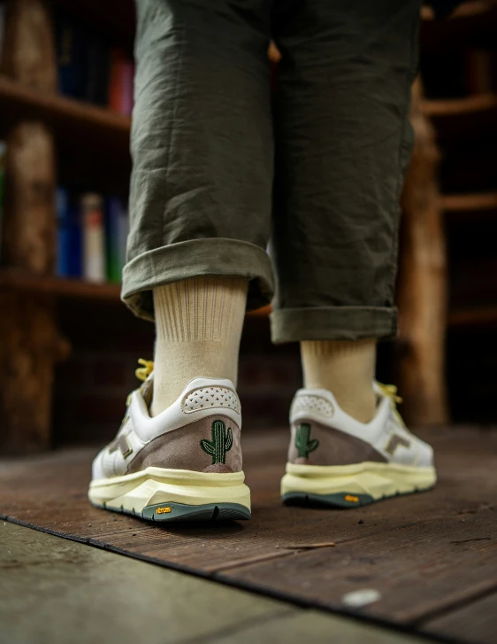 a person with brown shoes and socks walks on wooden floor