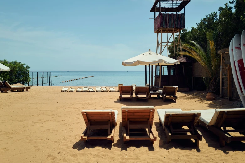 there are six lawn chairs on the beach