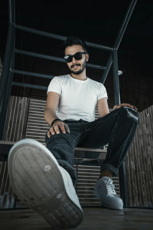 a man is sitting down wearing sunglasses