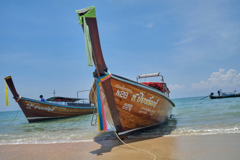 two fishing boats sitting on top of a beach