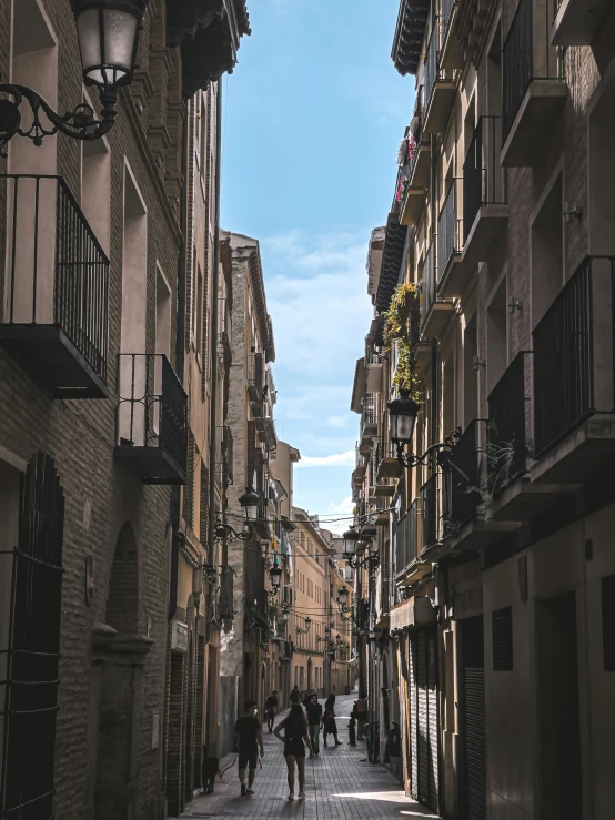 several people walk down a small street next to some building