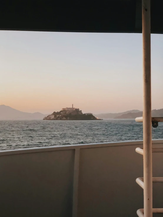 a view from the back of a boat in the ocean at sunset