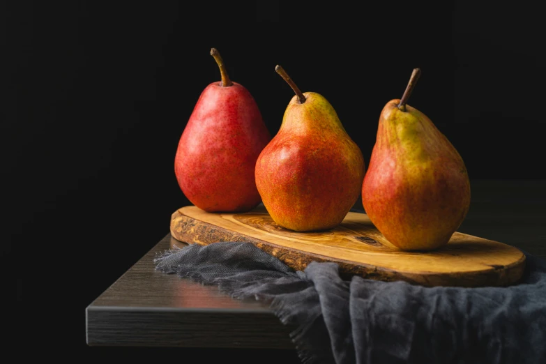 three pears and a one cut in half on a  board