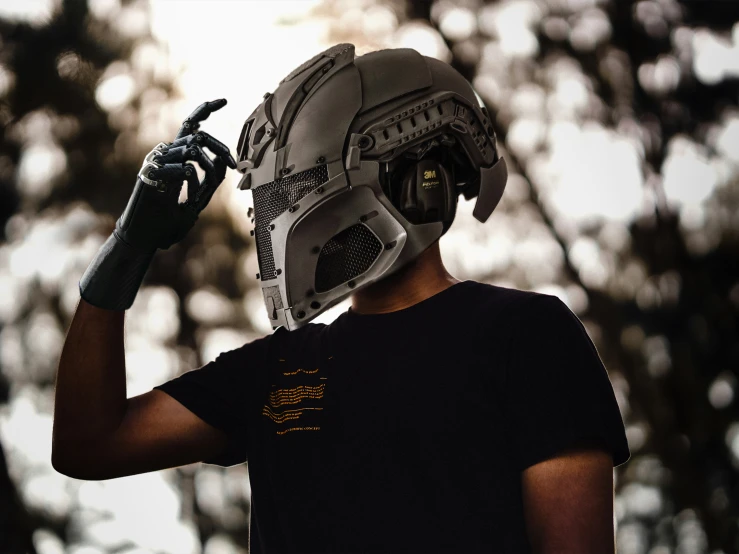 a boy wearing a gray helmet while pointing his finger