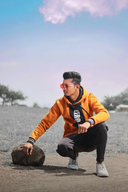 man crouched on the sand while petting the small animal