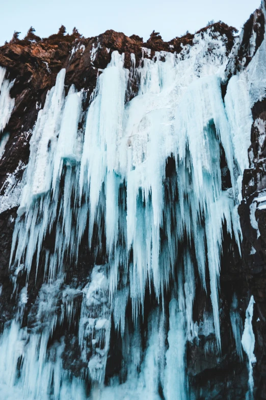 the icicles are hanging on to the side of a mountain