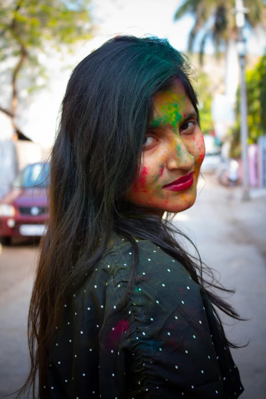 an image of girl with holi on face