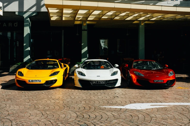 four colorful sports cars sitting in a parking lot