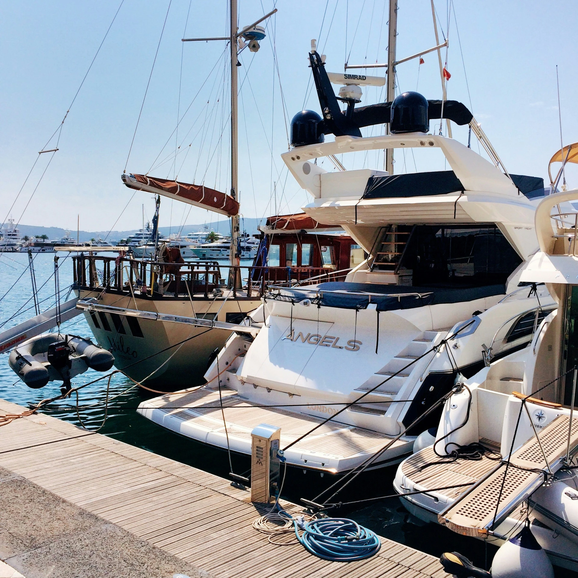 several large boats in the water by a dock