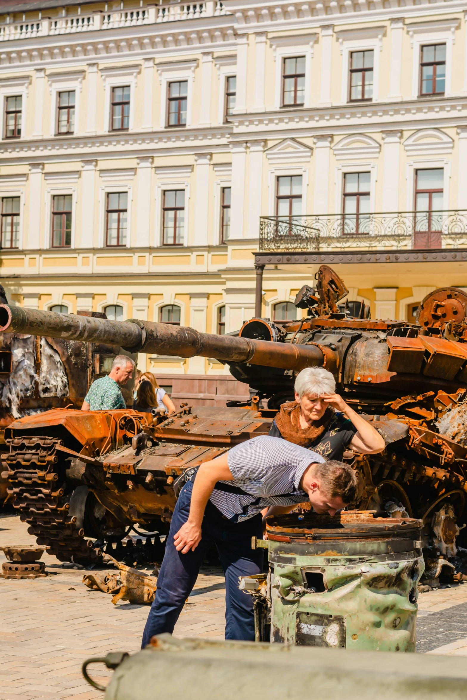 men look at many tanks in an open courtyard