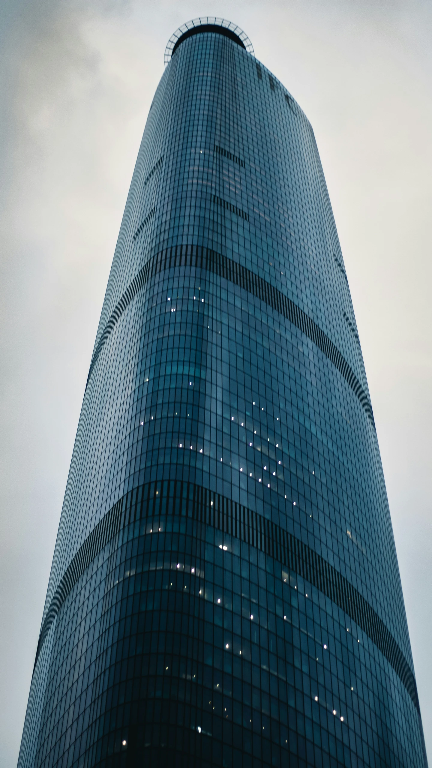 a very tall glass building with a sky background