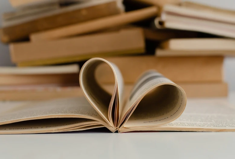 an open book on top of a pile of books