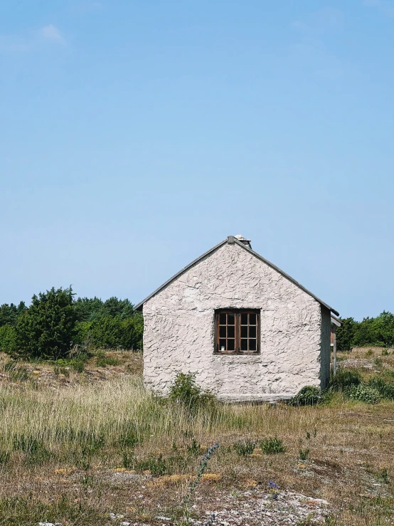 an old outbuilding sits in the middle of a field