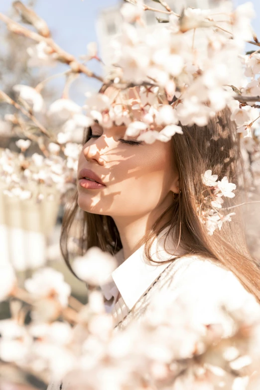 the woman is in the white flowers and is covering her eyes