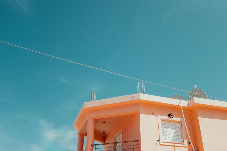 an orange house with white windows is under blue sky