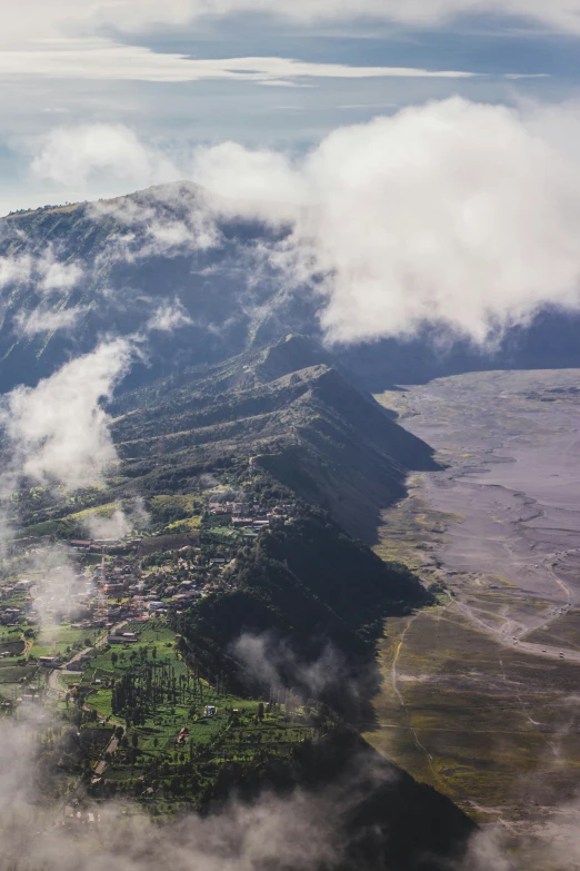 a view from an airplane shows the surrounding trees, hills and a town