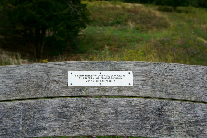 a park bench with a sign that reads international cemetery cemetery