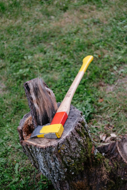 a toy colored axe sticking out of a tree stump