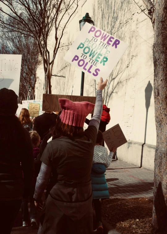 people protesting with a sign stating power for the polls