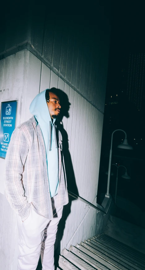 a person in a blue coat standing by the stairs