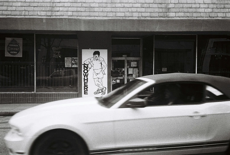 a white mustang on the side of a street