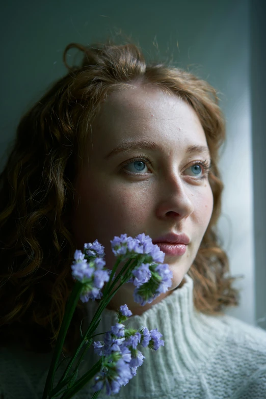 the woman is posing for a picture with some flowers