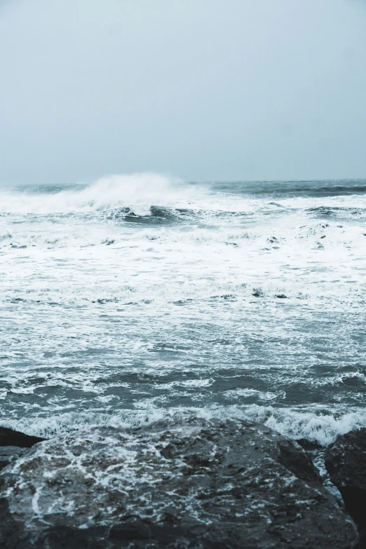 surfer on the edge of the beach waiting for his wave to come in