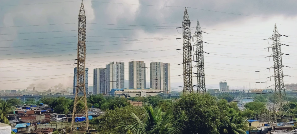 power lines in the foreground and large buildings in the distance