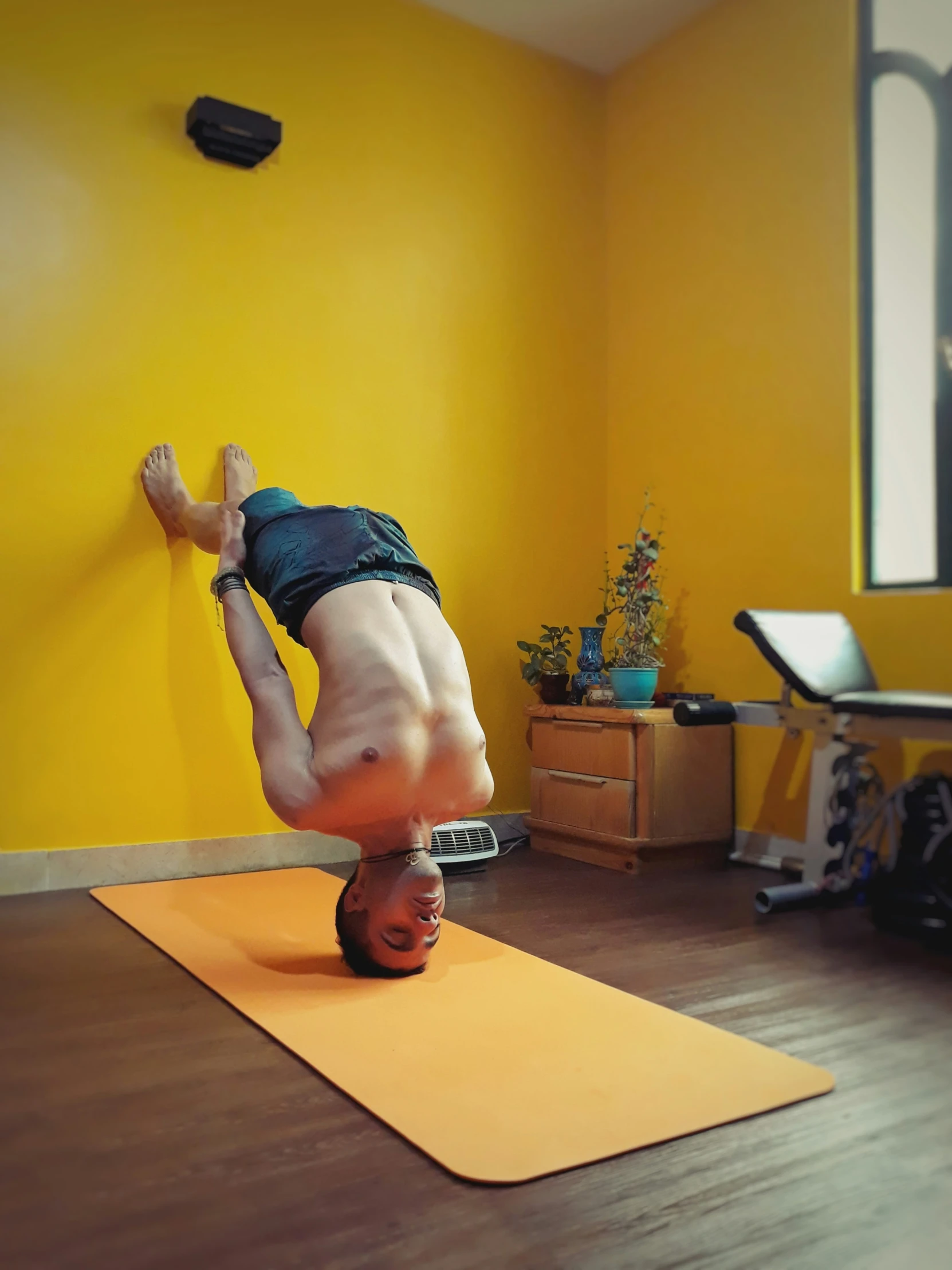 a man on one foot doing a handstand in a room