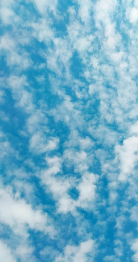 a jetliner in the sky with some clouds above