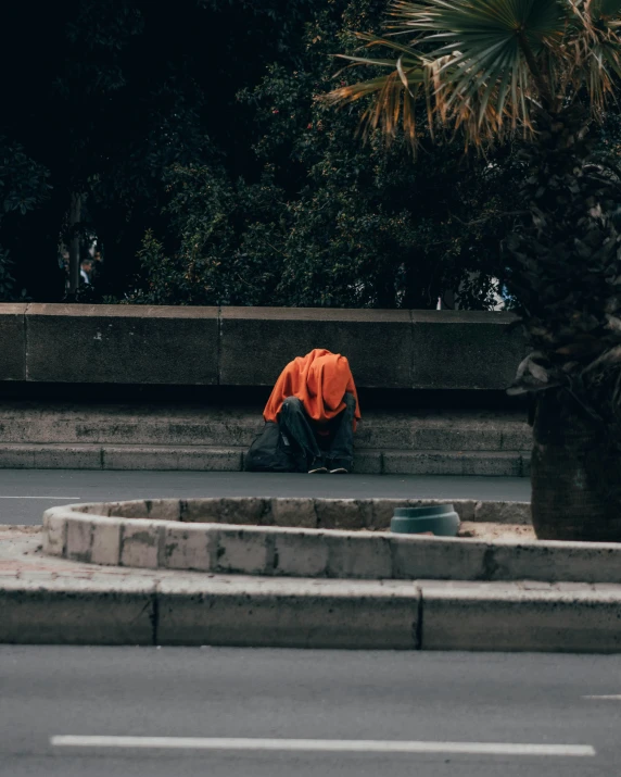 a man sitting on the sidewalk with his feet on the ground