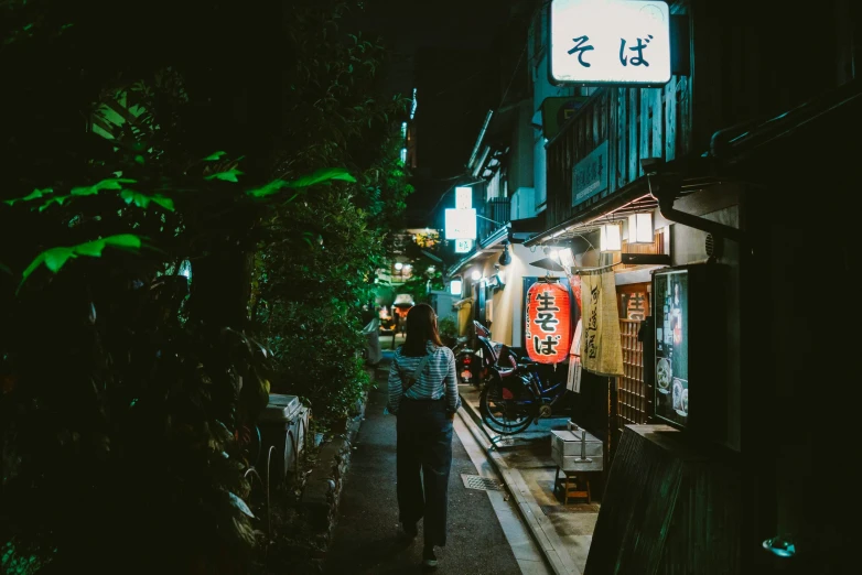 a woman walking down an alley at night