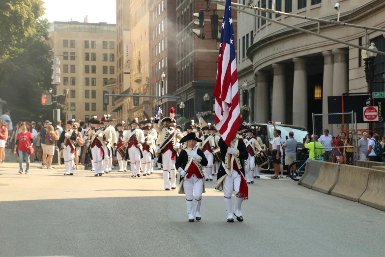 a bunch of people walking down the street in uniform