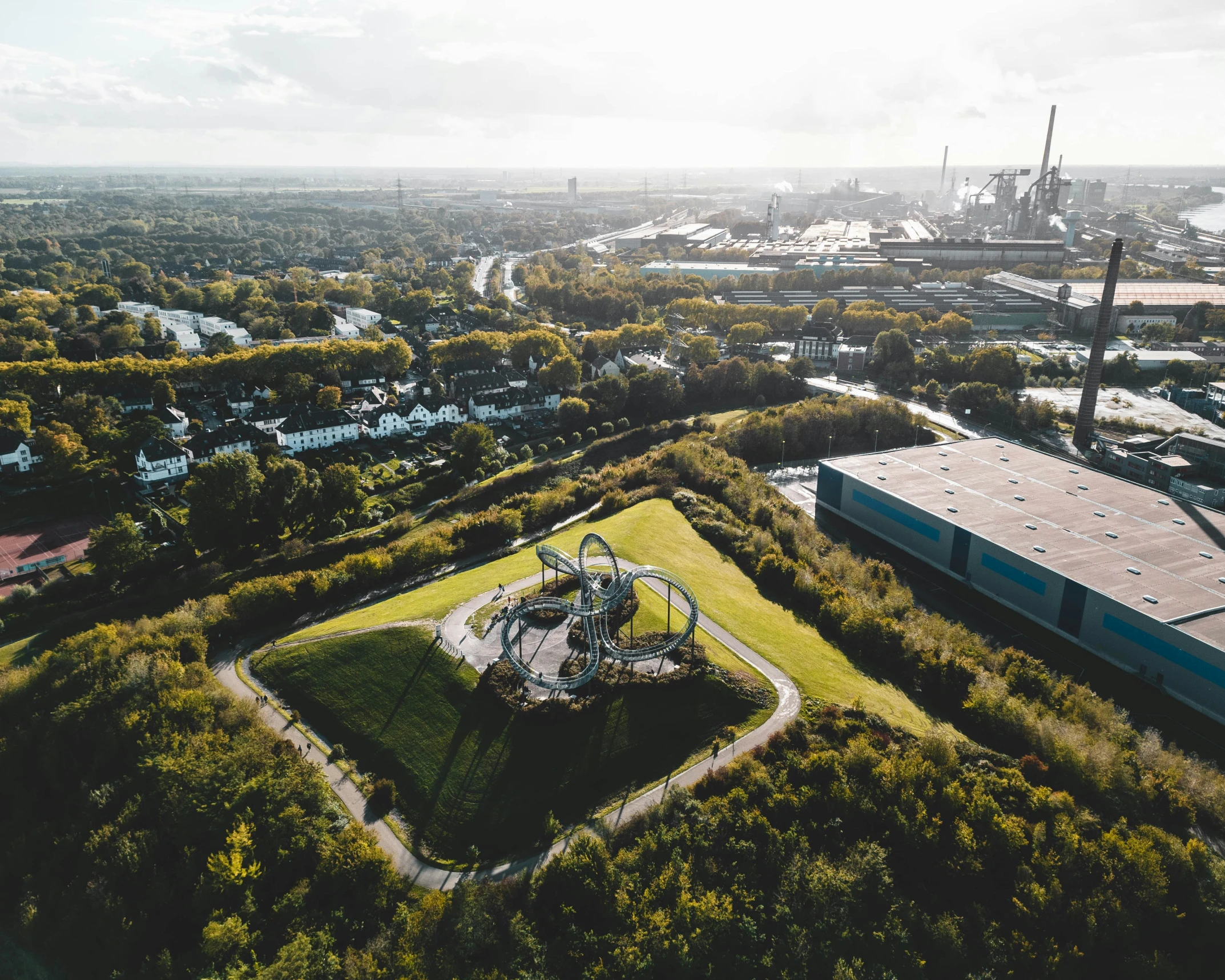 an aerial s of a park in the middle of trees and buildings