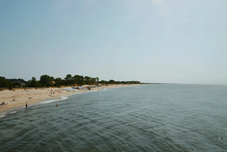 a beach with some people on it near the water