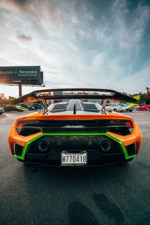 an orange and black sports car with a green tail stripe