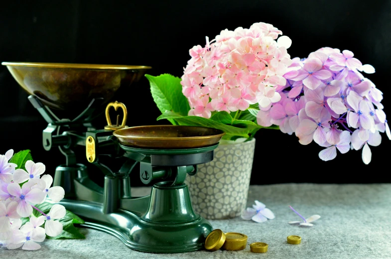 a vase of flowers and flowers near a grinding stone