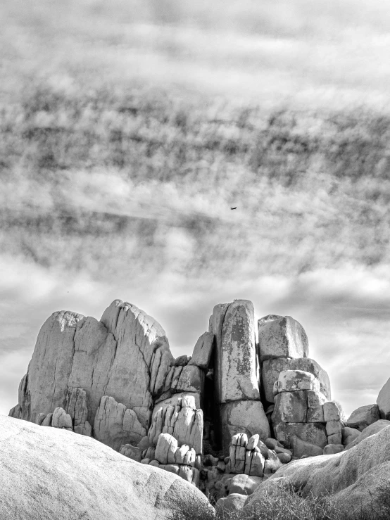 rocks are on a grassy hill against the sky