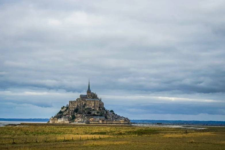 a lone tower on an island surrounded by grass