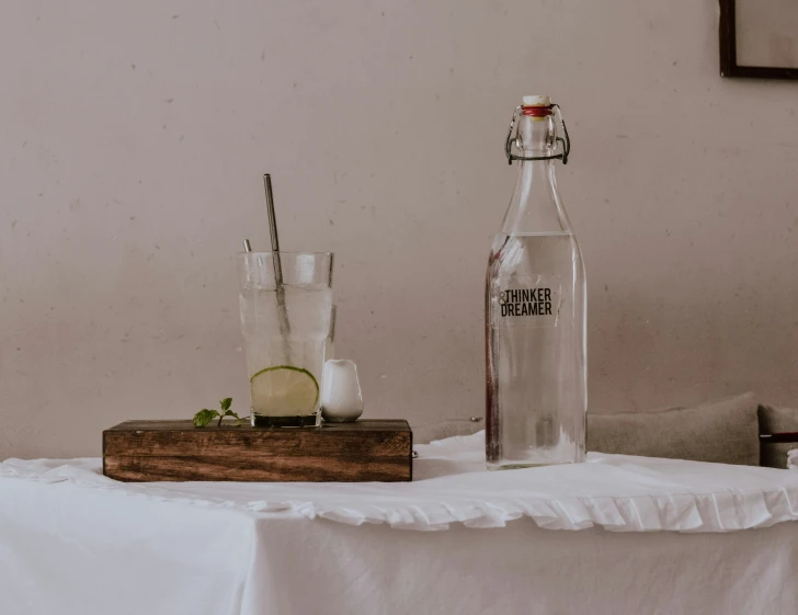 a bottle and some glasses are on a table