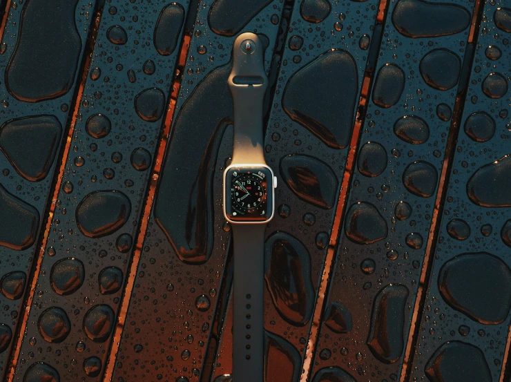 a wet apple watch sitting on top of a rainy table