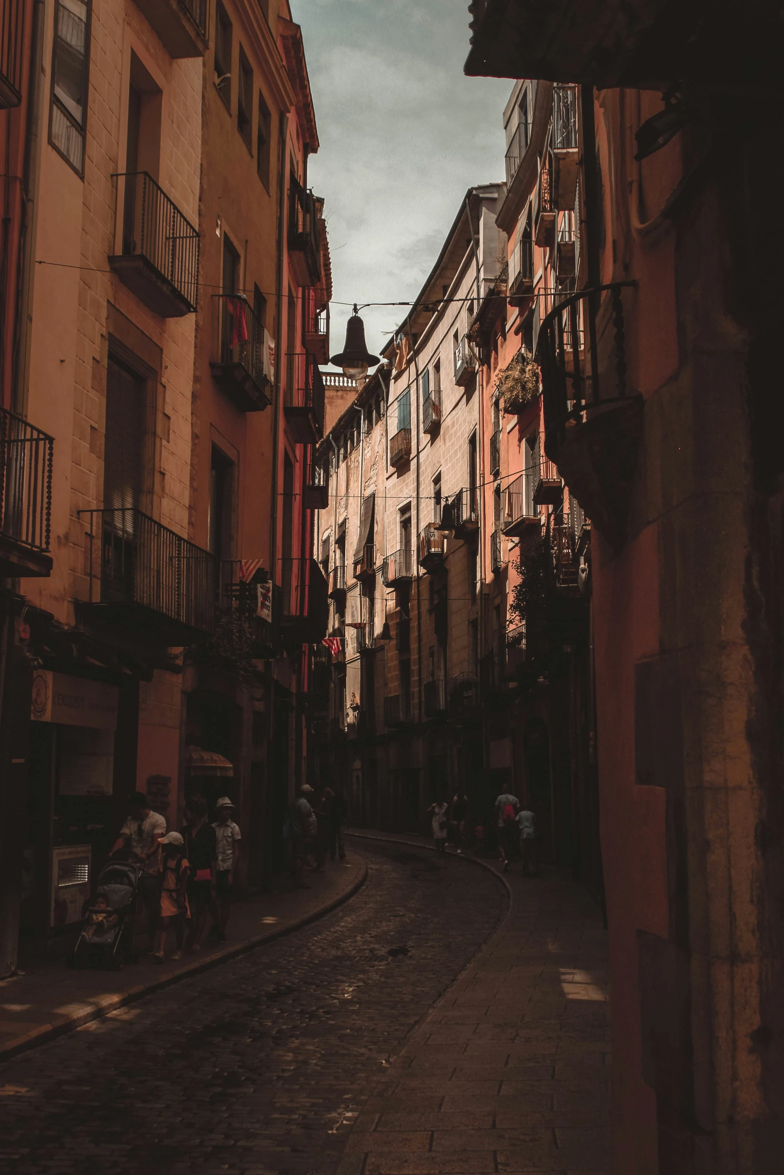 a narrow street lined with tall buildings with balconies