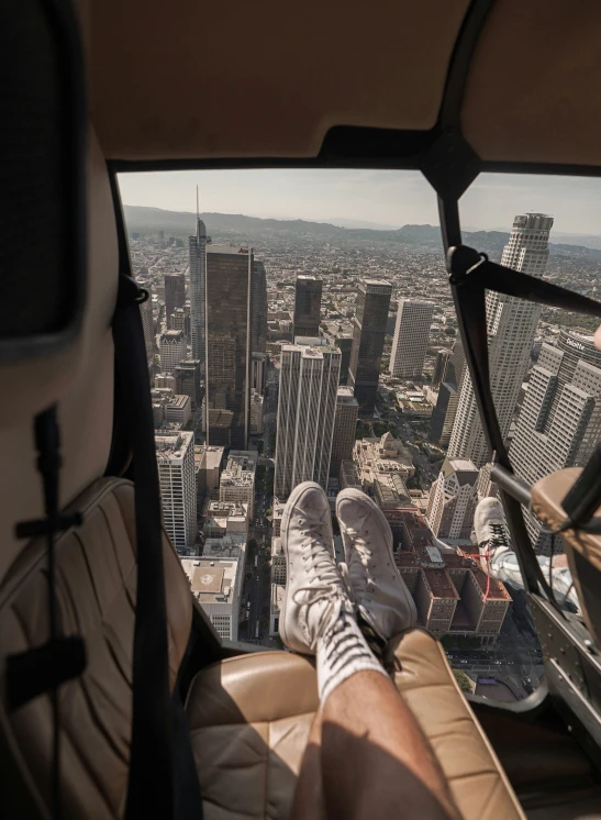 someone's feet are in the middle of a window looking out over a city