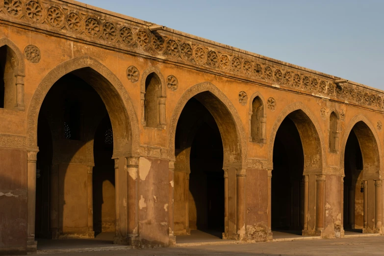 the arched stone and stucco building has arches on each side